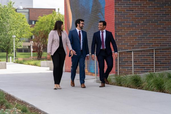 3 business school students walking together on campus